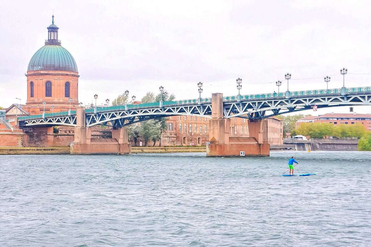 man paddleboarding in river in Toulouse