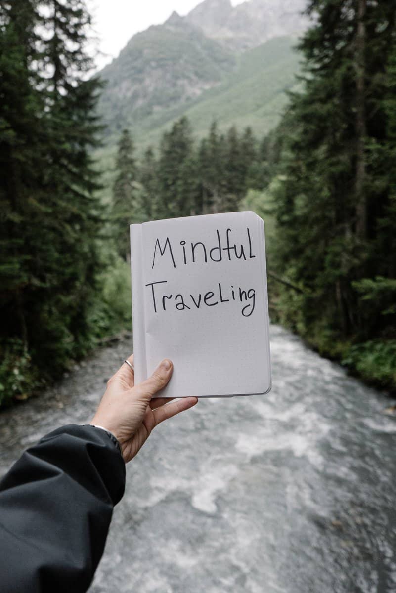 hand holding a sign saying mindful travel