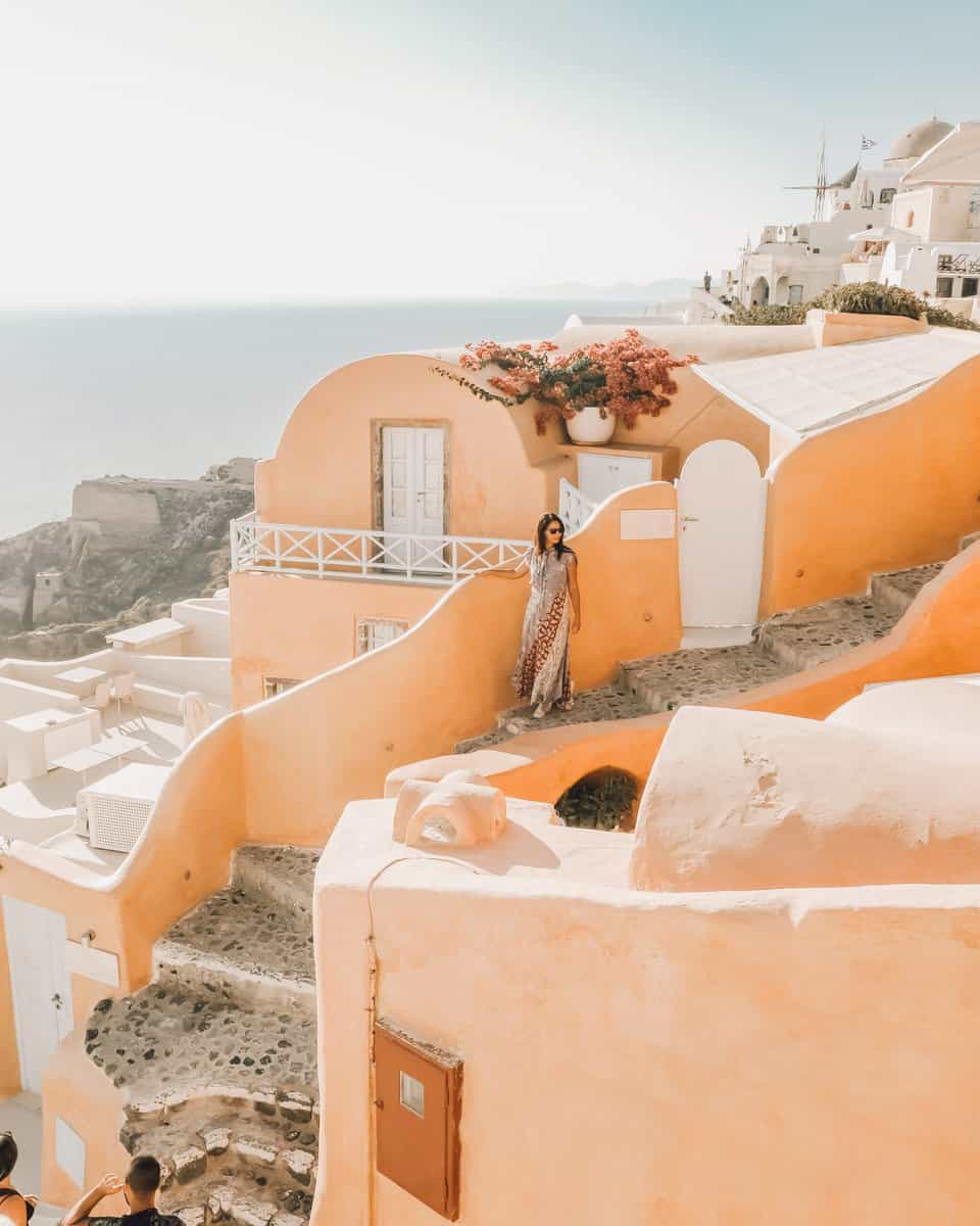 orange house in Santorini, girl leaning on wall