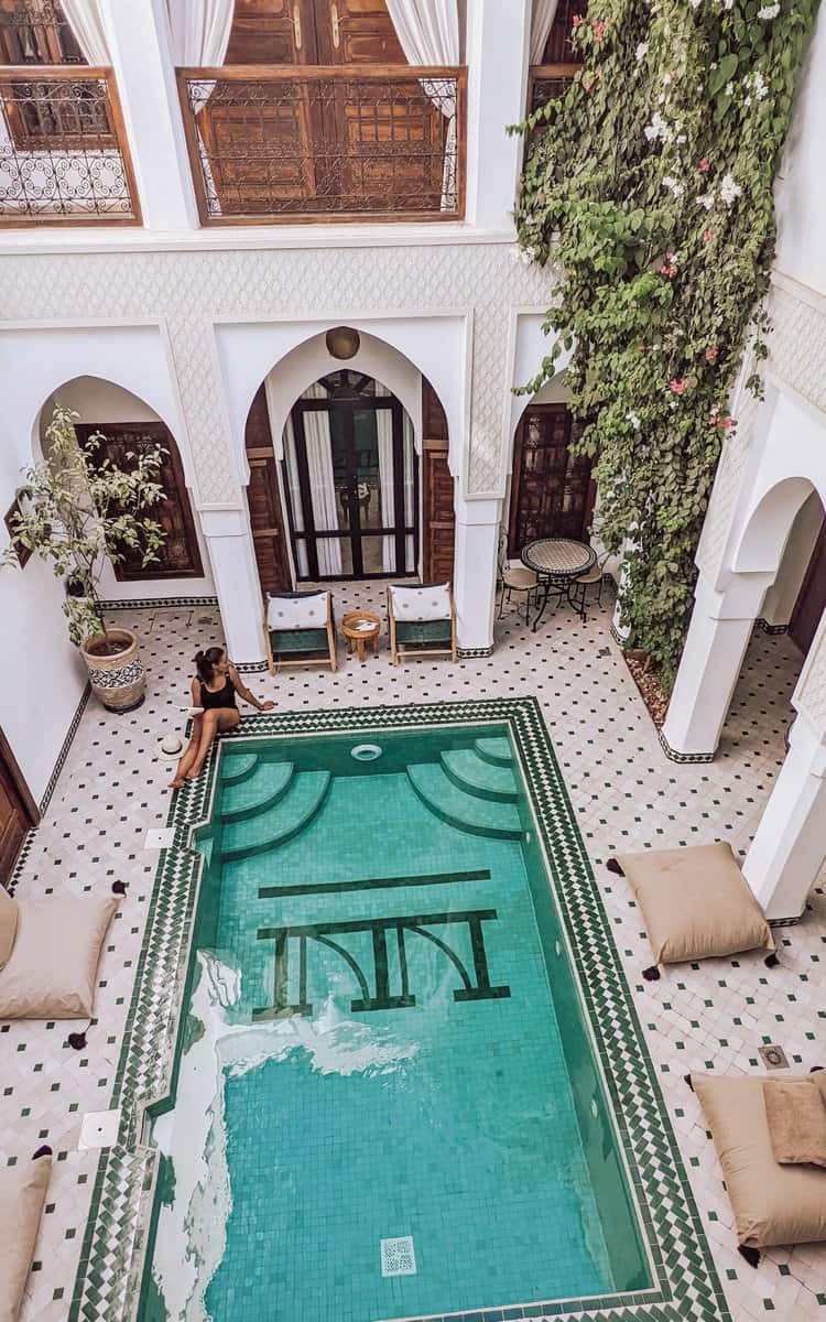 girl sitting by swimming pool in riad