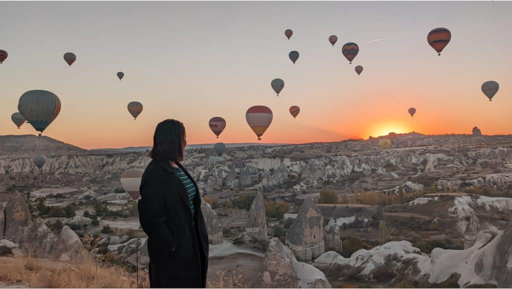 girl watching sunrise and balloons