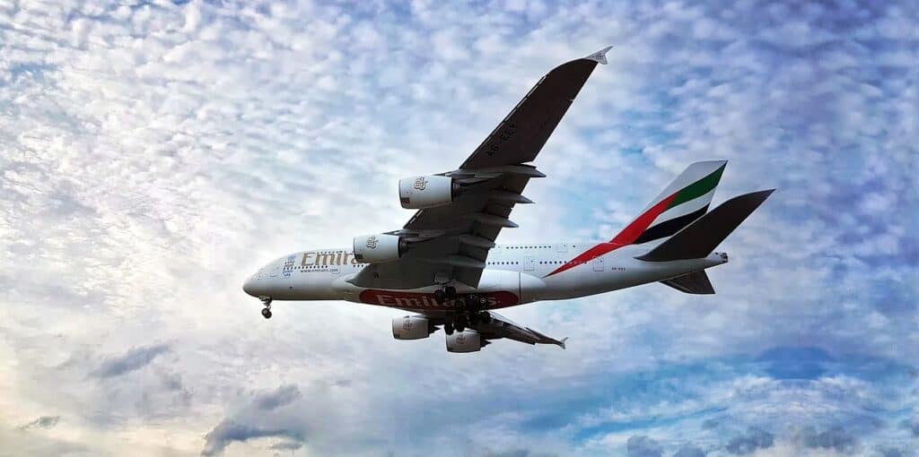 Emirates aircraft flying below clouds