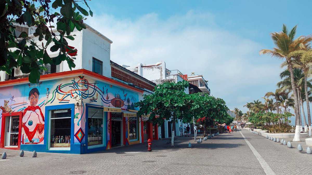 A vibrant building adorned with a captivating mural on its side, showcasing a burst of colors.