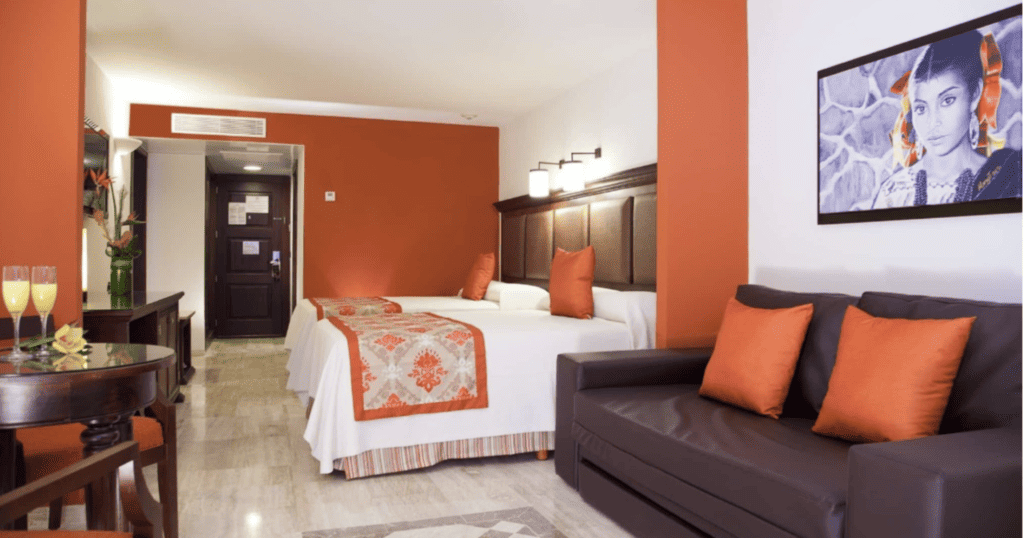 Double beds and sofa in a brown and orange decor at Grand Palladium puerto vallarta