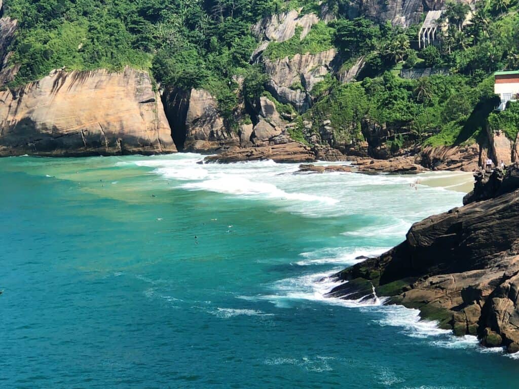 Close up view of an emerald green beach in Rio de Janeiro surrounded by green vegetation 