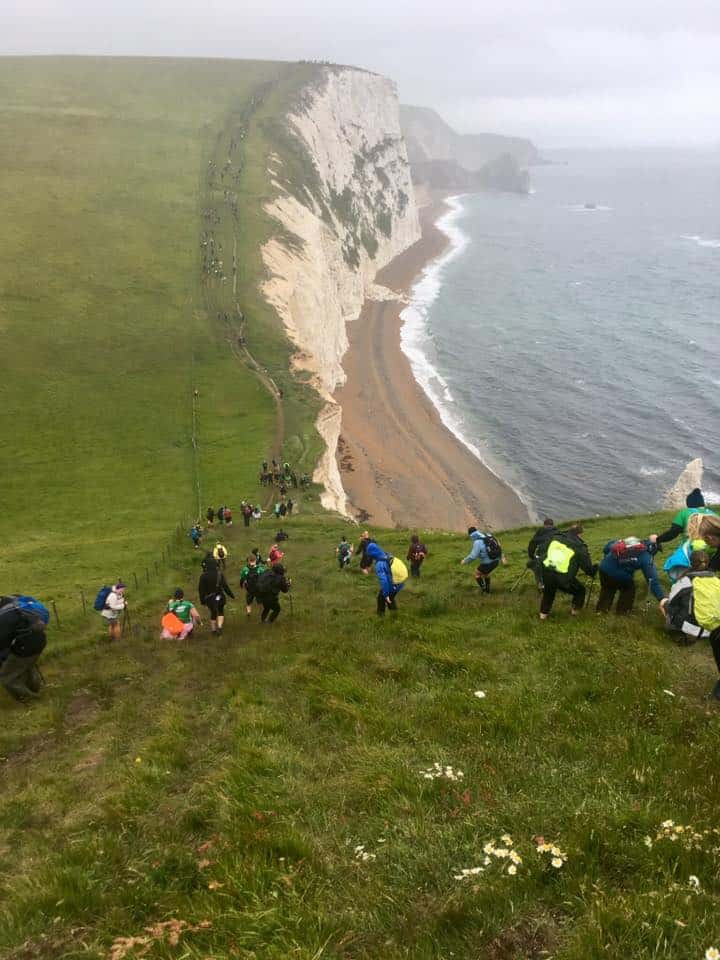 a group of people going down the hills on the jurassic coast mighty hike