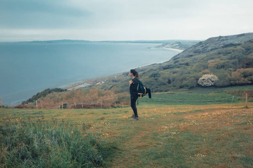Girl standing on a hill, preparing for the jurassic coast mighty hike