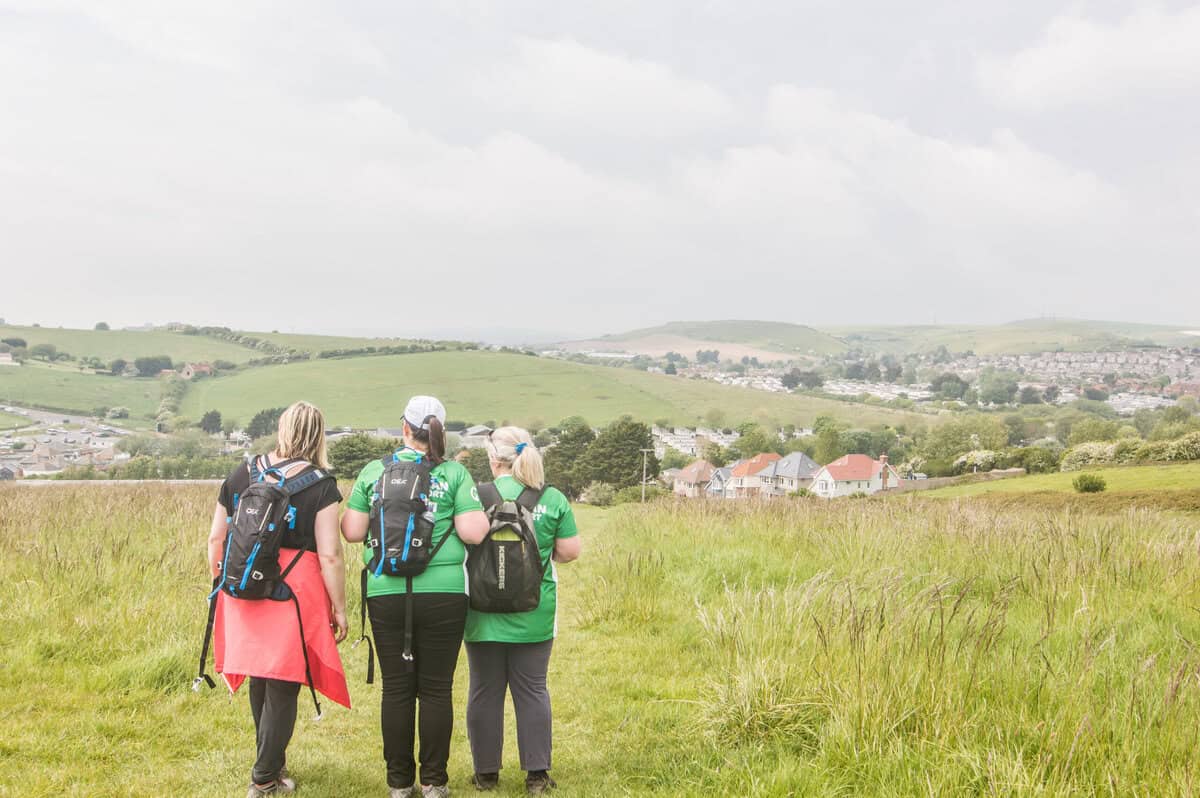 three women on a hill, preparing for the jurassic coast mighty hike