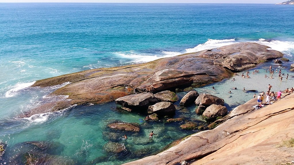 crystal clear water and a small natural pool with sunbathers in rio de janeiro