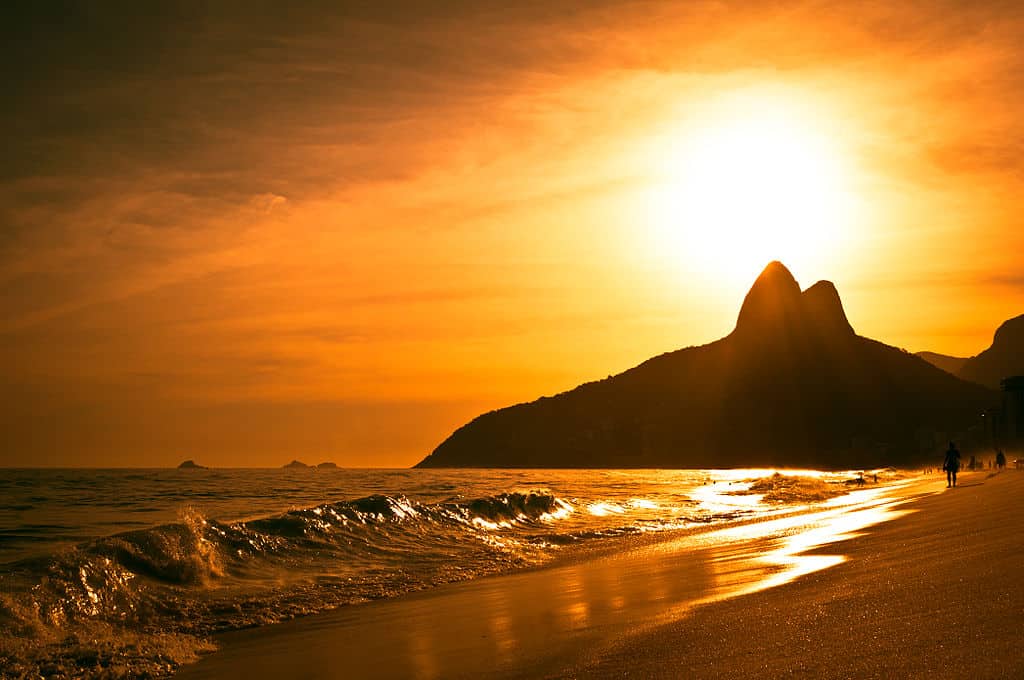 fiery yellow sky on an empty beach and a mountain in the background