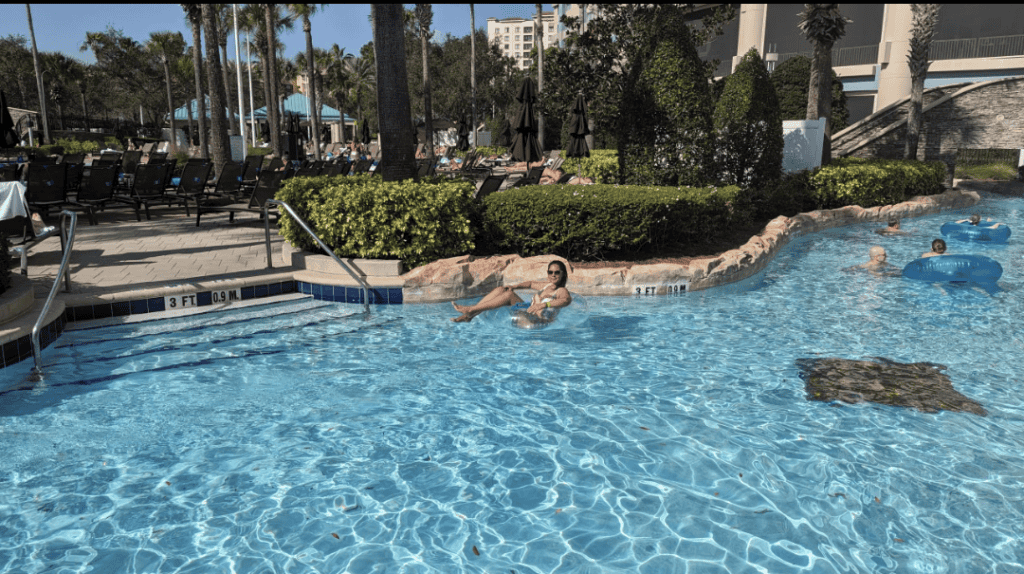 Luxury travel for less: girl in blue swimming pool at a resort